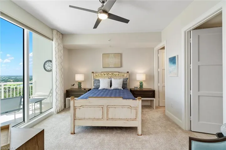 Bedroom featuring light colored carpet, access to outside, and a ceiling fan