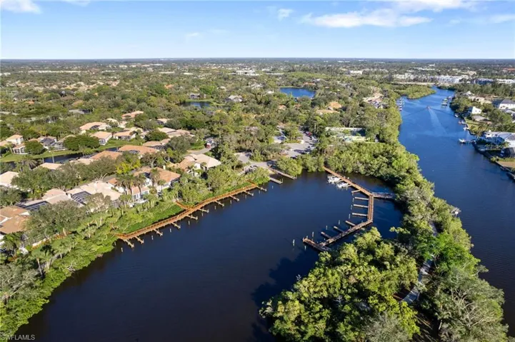 Aerial view of residential area with a nearby body of water and a tree filled landscape