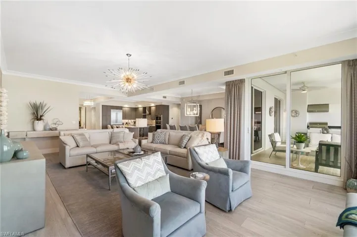 Living area with a chandelier, light wood finished floors, and ornamental molding