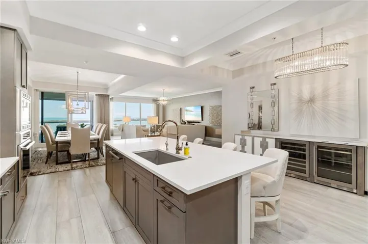 Kitchen with a chandelier, a sink, open floor plan, oven, and light countertops