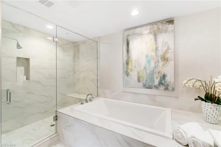 Full bathroom featuring a marble finish shower, a bath, and recessed lighting