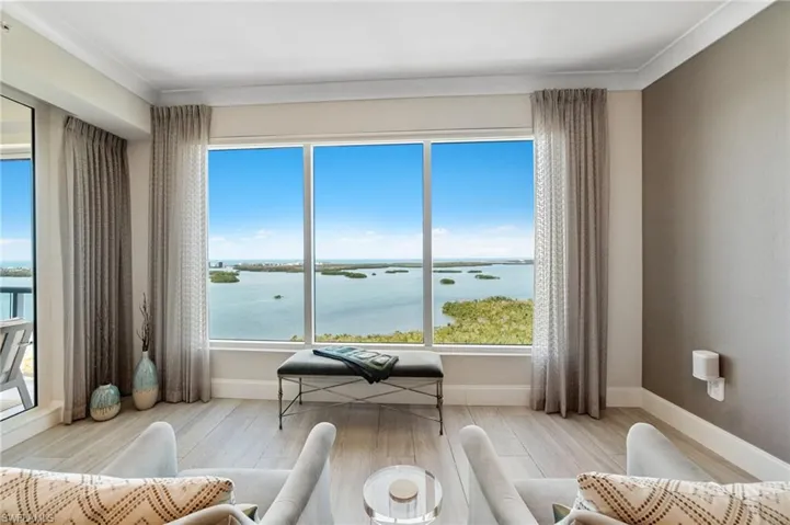 Living area with wood finished floors, baseboards, a water view, and crown molding