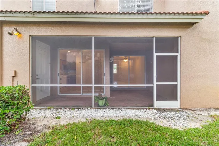 View of exterior entry with stucco siding, a sunroom, and a tiled roof