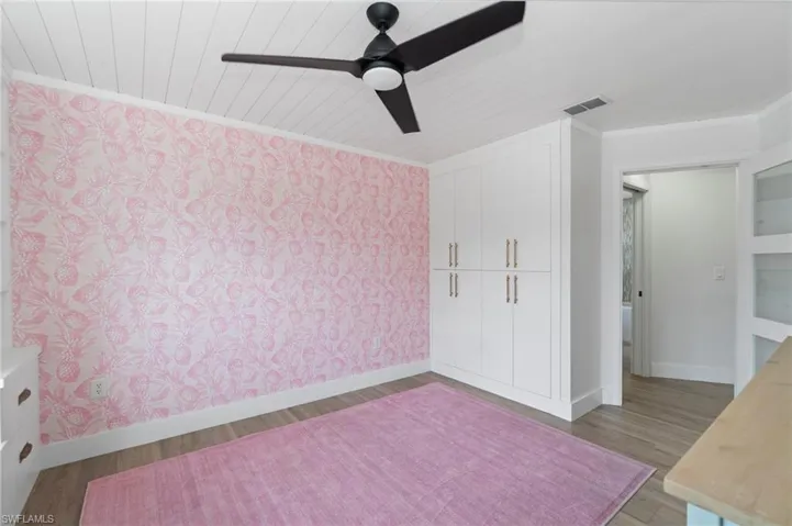 Unfurnished bedroom with ornamental molding, light wood-style floors, a ceiling fan, and a closet