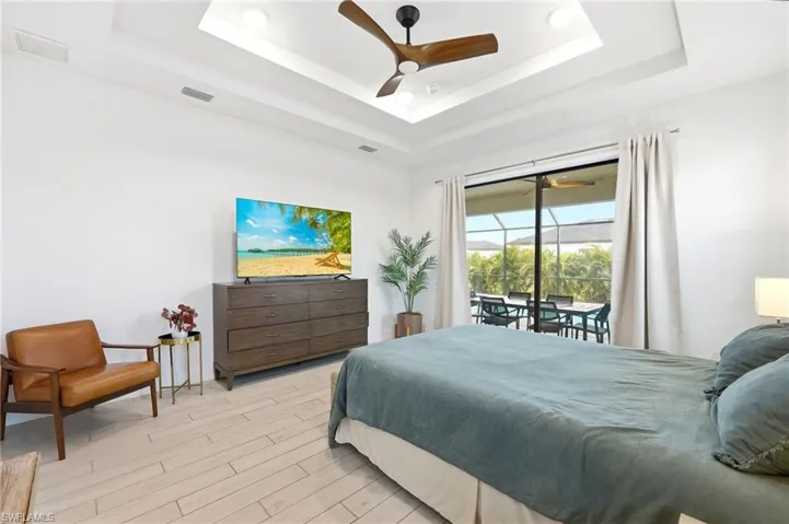 Bedroom with wood finish floors, access to outside, and a ceiling fan