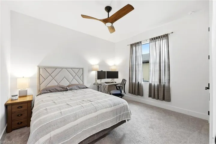 Bedroom featuring light carpet and ceiling fan