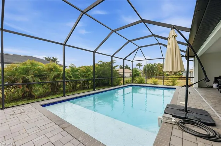 Swimming pool featuring a sunroom, a lanai, and a patio area