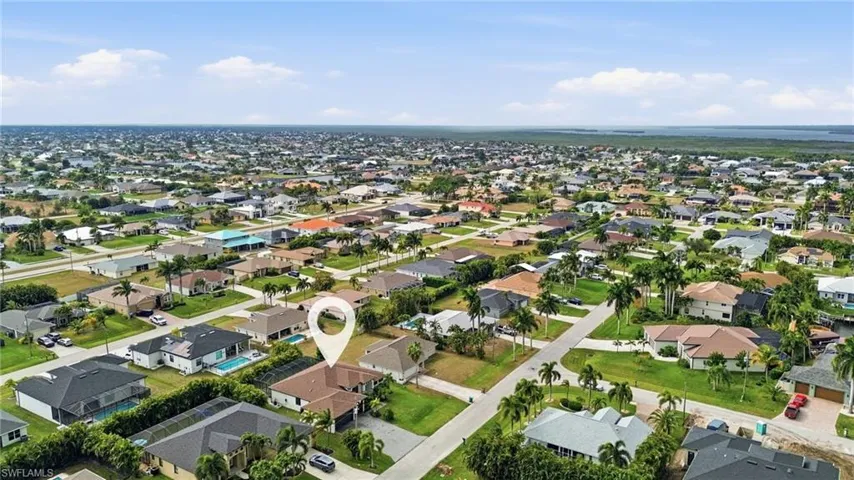Aerial view of property and surrounding area featuring nearby suburban area