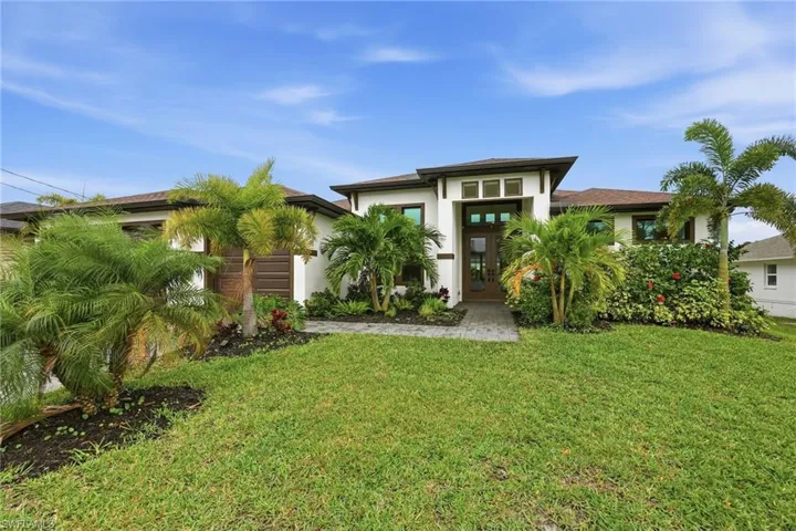 View of front of house featuring a front lawn and stucco siding