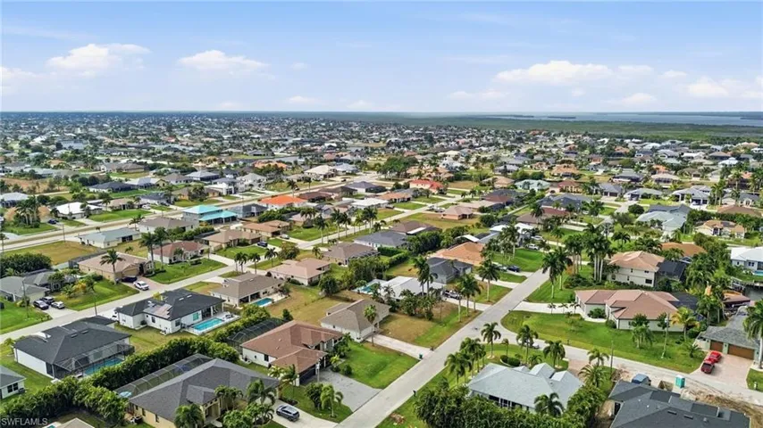 Aerial view of property and surrounding area with nearby suburban area