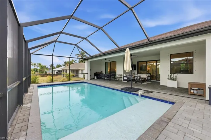 Outdoor pool featuring a sunroom, glass enclosure, a patio area, and outdoor lounge area