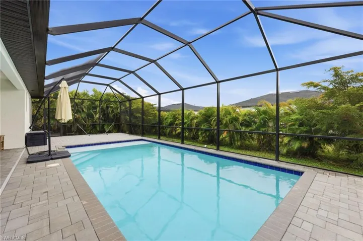 Outdoor pool with a sunroom, a lanai, a patio, and a mountain view