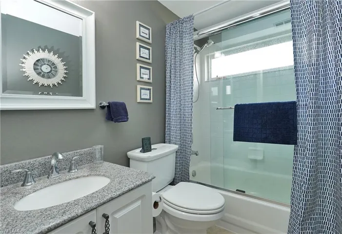 Bathroom featuring vanity and combined bath / shower with glass door