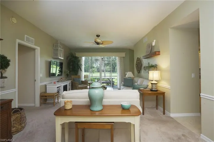 Carpeted living room featuring ceiling fan
