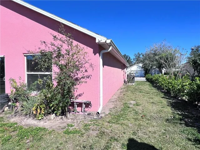 View of side of property with a lawn and stucco siding