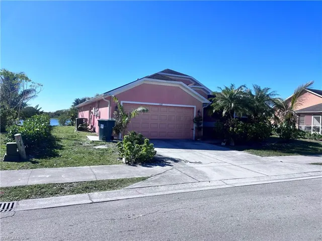 Single story home featuring concrete driveway, stucco siding, a front yard, and an attached garage