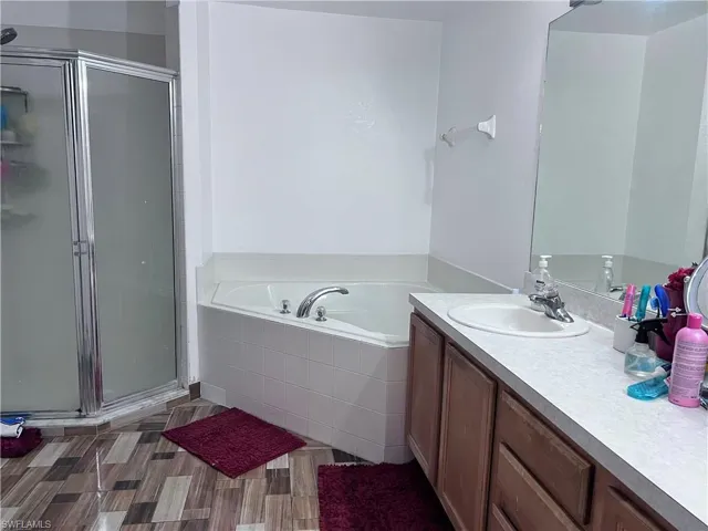 Full bath featuring a bath, vanity, and a stall shower