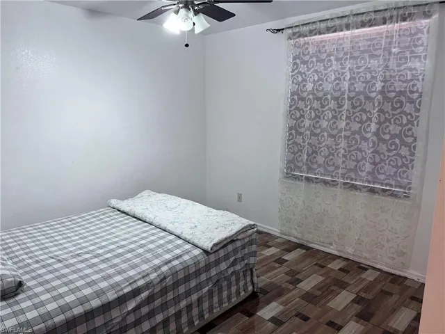 Bedroom featuring dark wood-style floors and ceiling fan