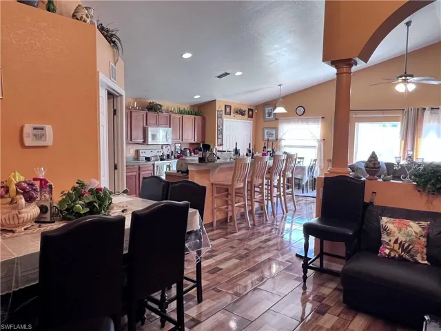 Living area with ceiling fan, lofted ceiling, recessed lighting, and arched walkways