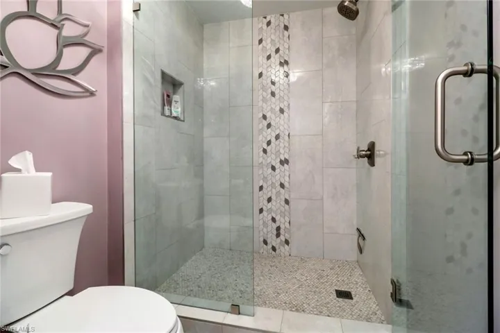 Bathroom featuring an enclosed shower and toilet