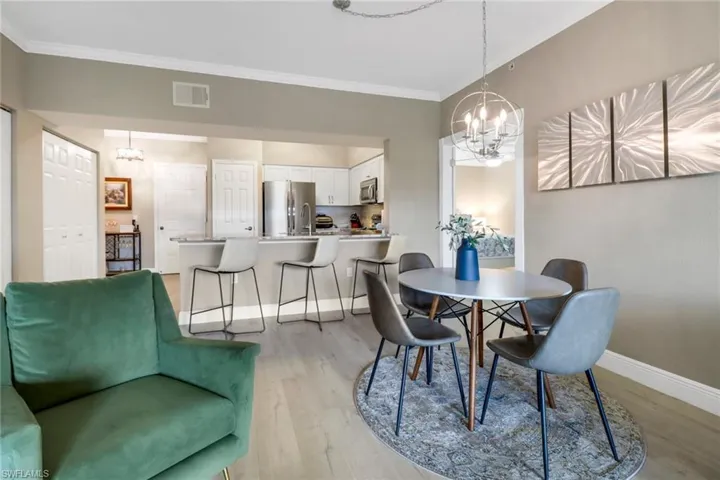 Dining area featuring light hardwood / wood-style floors, a notable chandelier, and crown molding
