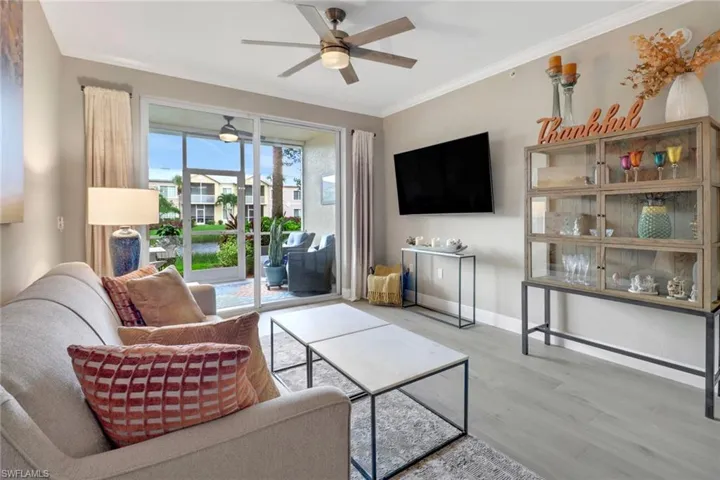Living room featuring ceiling fan, crown molding, and hardwood / wood-style flooring