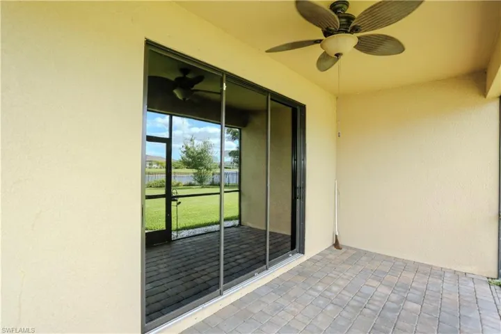 Covered patio featuring paver flooring, a ceiling fan, and sliding glass doors with a screen enclosure