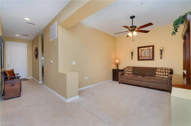 Carpeted living room with ceiling fan