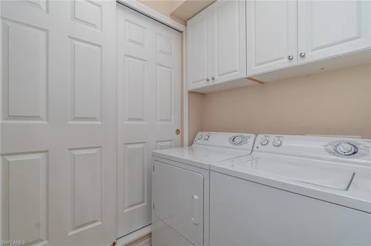 Washroom with cabinets and washer and dryer