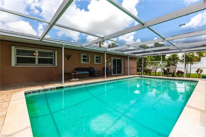 View of swimming pool featuring a patio and glass enclosure