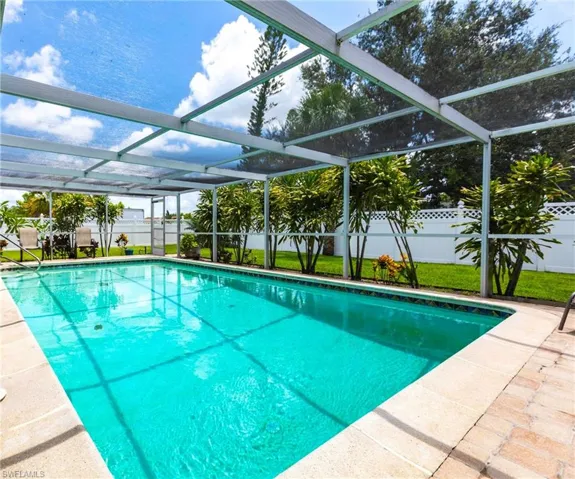 View of swimming pool with a fenced backyard, a lanai, and a patio area