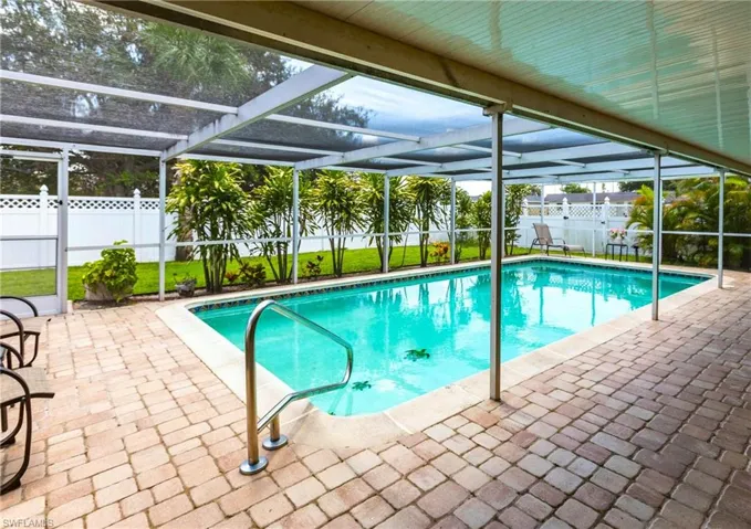 View of swimming pool with a lanai, a fenced backyard, and a patio area