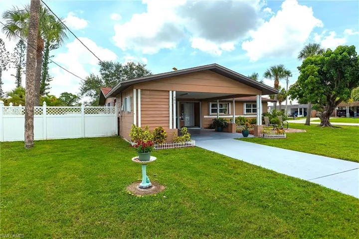 View of front of house with an attached carport and concrete driveway