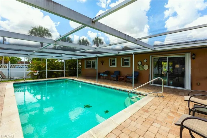 View of swimming pool featuring a patio and glass enclosure