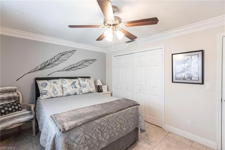Bedroom featuring crown molding, a closet, and ceiling fan