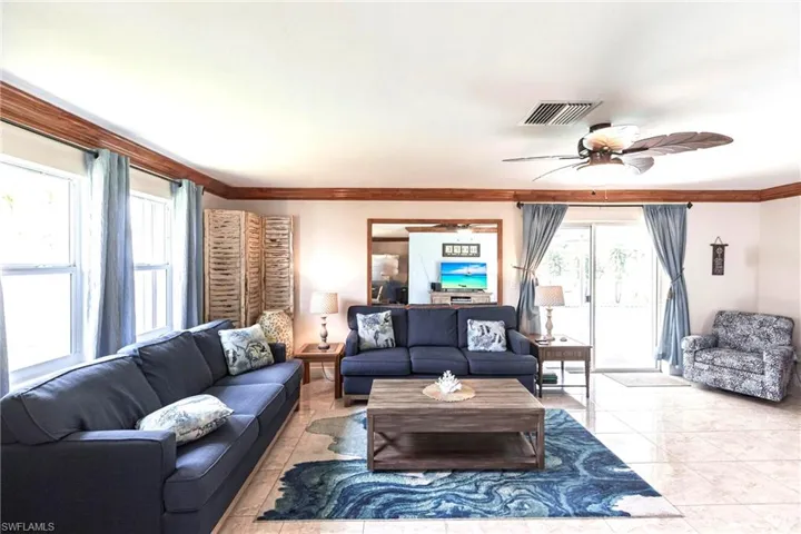 Living area featuring ceiling fan and crown molding