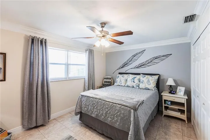 Bedroom featuring ornamental molding, a ceiling fan, and a closet