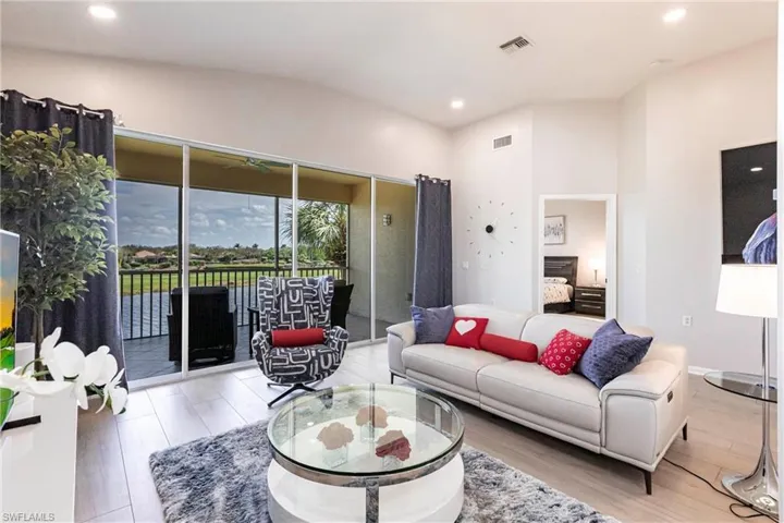 Living room with recessed lighting, wood finished floors, and a water view