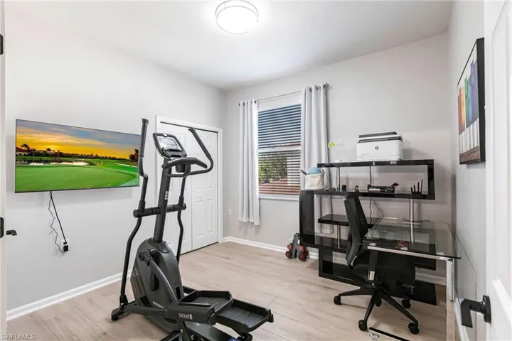 Exercise room featuring light wood-style floors and baseboards