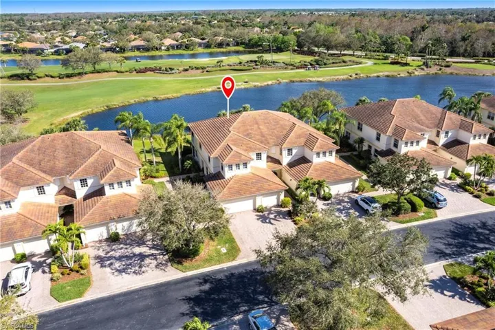Aerial view of residential area with a nearby body of water and a golf club
