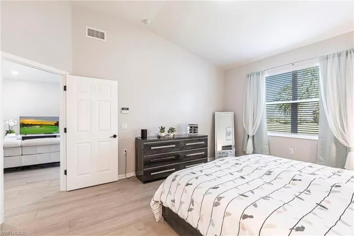 Bedroom featuring light wood-style flooring and high vaulted ceiling