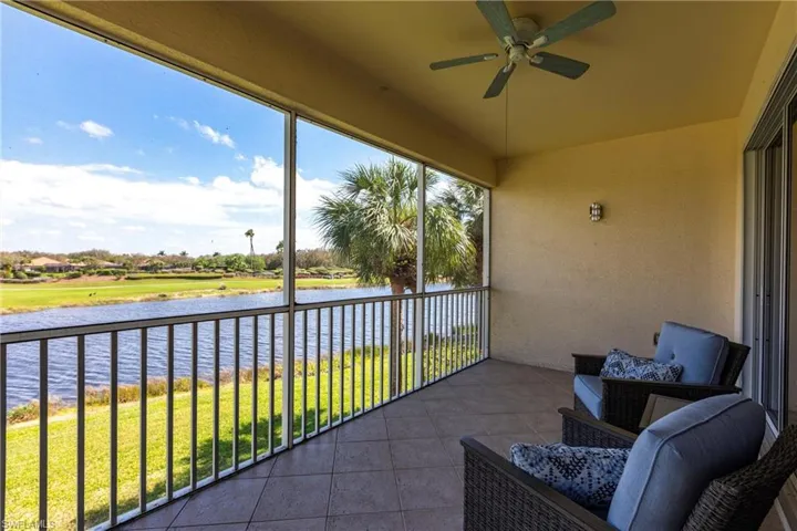 Balcony with a water view, ceiling fan, and a sunroom
