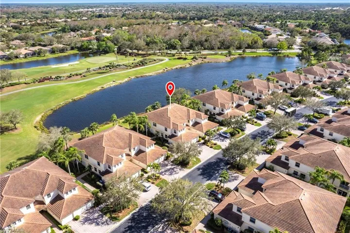 Aerial perspective of suburban area featuring a golf club and a large body of water