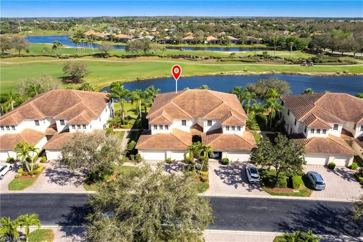 Aerial view of residential area with a nearby body of water and a local golf course