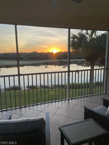 Balcony with a sunroom, a water view, and ceiling fan