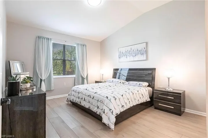Bedroom with vaulted ceiling and light wood finished floors