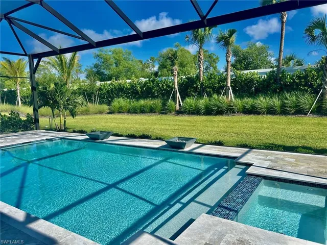 View of pool featuring a lanai and a yard