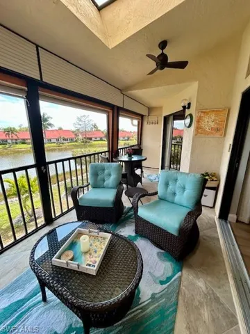 Lanai with a ceiling fan, a water view, vaulted ceiling, and a skylight