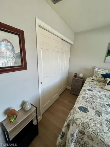 Bedroom featuring dark wood-style floors and a closet