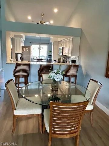 Dining room with wood finished floors, ceiling fan, and recessed lighting
